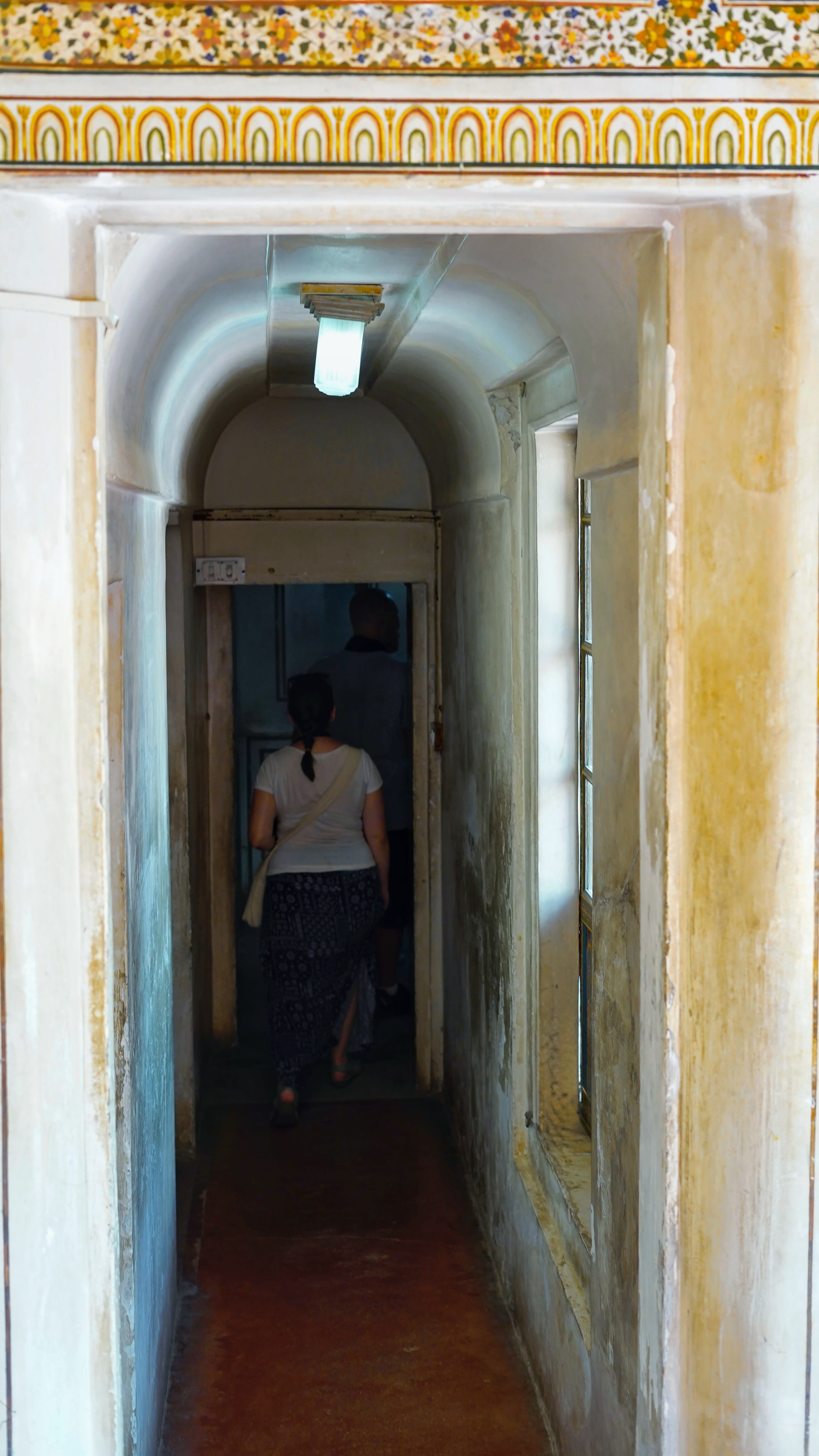 Sunlit fort courtyard in north India with travellers exploring